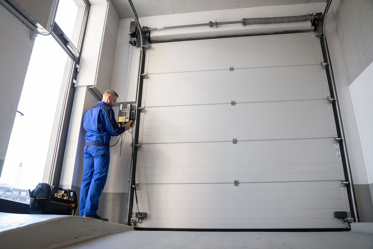 Technician servicing a sectional garage door opener