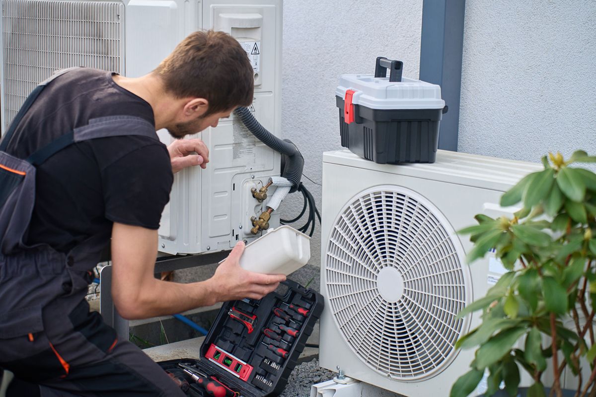 HVAC technician servicing a residential heat pump